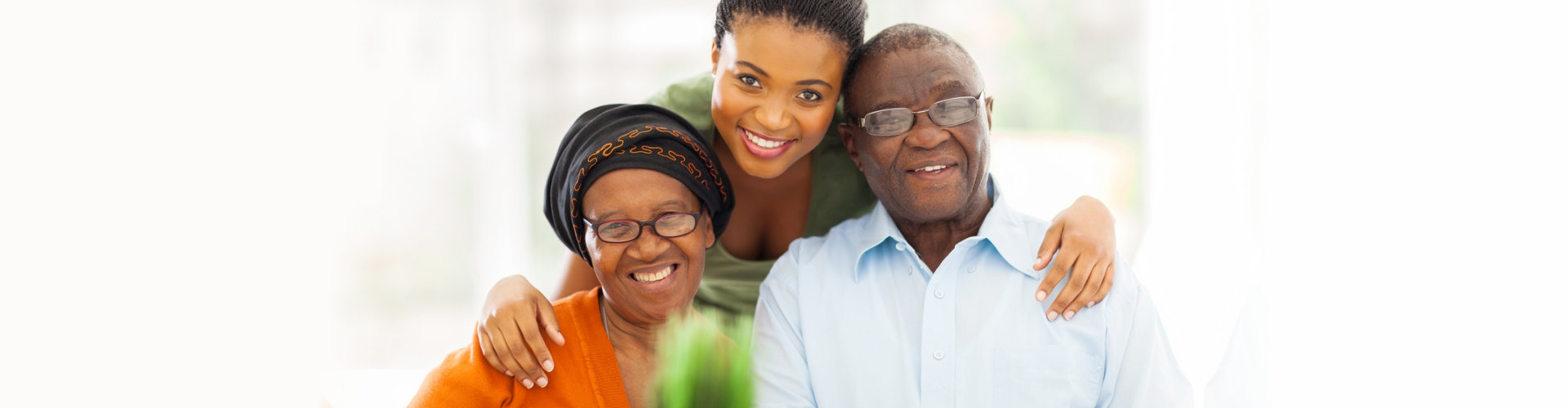 female caregiver and senior couple smiling