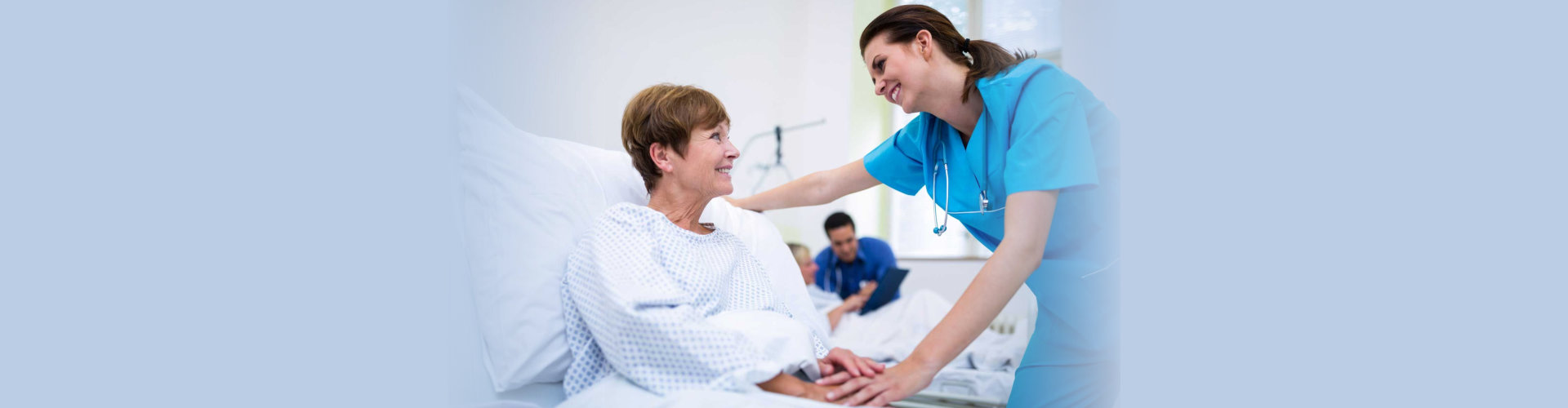 Nurse consoling a patient in ward at hospital